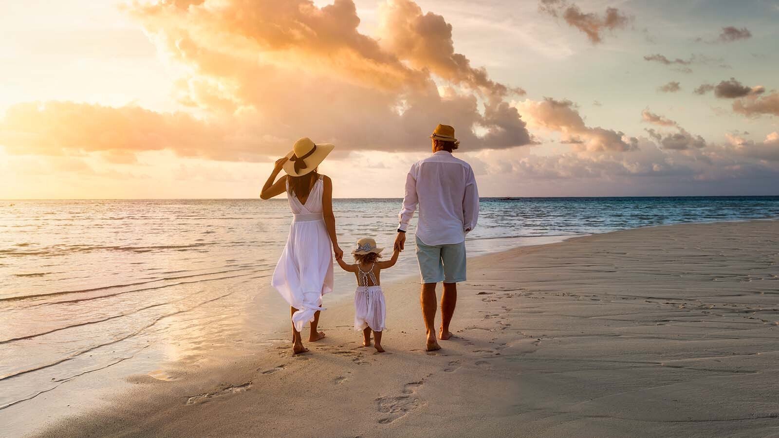 familia caminando por la playa al atardecer