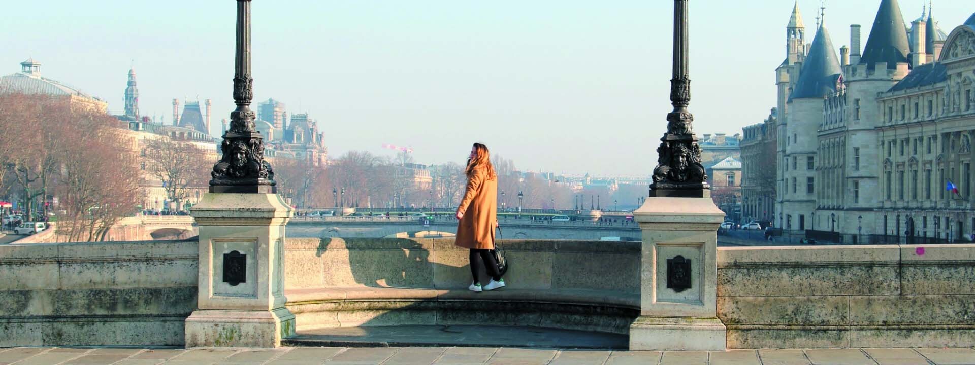 Mujer en un puente mirando el paisaje durante sus vacaciones